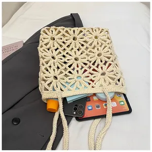 Detail of floral crochet tote bag showing interior storage for phone and tablet