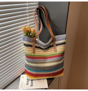 Detail of colorful rainbow stripe woven straw tote bag with sturdy leather shoulder straps