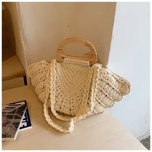 Macro detail of bohemian cream crochet handbag with shell knit and wooden handle