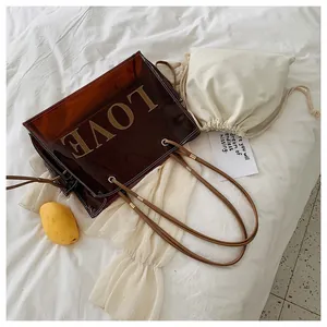Close-up of brown translucent PVC tote with LOVE embroidery and canvas inner bag