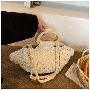 Detailed knit texture and wooden handles of the cream fan-shaped woven handbag