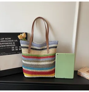 Close-up of rainbow striped woven tote bag featuring durable brown leather handles