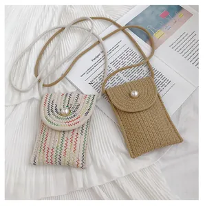 Détail de mini sac bandoulière tissé avec boucle de perle et texture en paille
