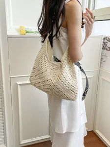 Chic cream hollow knit shoulder bag with metal rings for a bohemian summer beach look