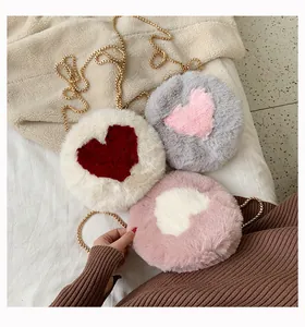 Detailed view of plush heart crossbody bags with gold chains in three soft colorways