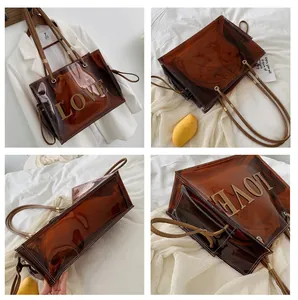 Macro detail of brown transparent PVC tote bag with LOVE letter patch and leather straps