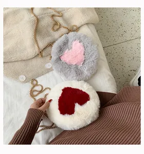 Detail of round plush crossbody bags with heart patterns and gold metal chain straps