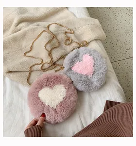 Detailed shot of soft faux fur crossbody bags with heart patterns and gold chains