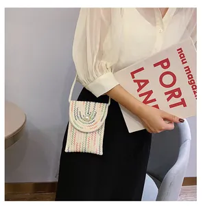 Détails d'un petit sac bandoulière tissé avec bouton perle et motif de vagues multicolores
