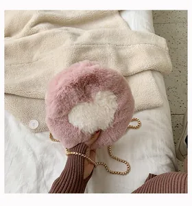 Detail of soft plush round crossbody bag with white heart pattern and gold metal chain