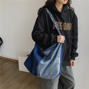 Large denim patchwork shoulder bag with rope straps shown on model in minimalist setting