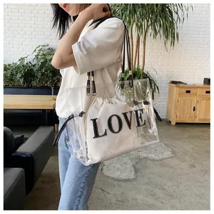 Detail of transparent PVC tote bag with white drawstring pouch featuring LOVE lettering