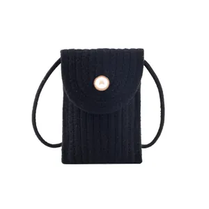 Petit sac bandoulière noir tissé pour femme avec fermoir perle élégant sur fond blanc