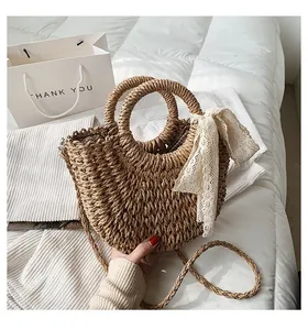 Detailed straw handbag with lace ribbon, round handles and brown polka dot lining