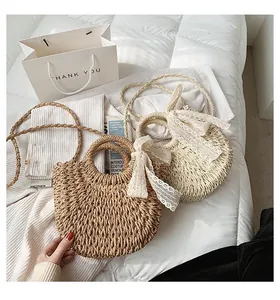 Detail of straw woven beach bags with lace bows in cream and dark brown colors