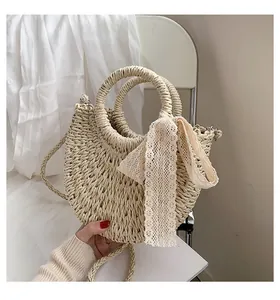 Detailed close-up of handmade straw tote bag with elegant lace bow and round handles