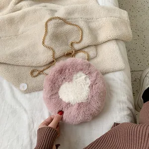 Pink plush round crossbody bag with white heart pattern and gold chain strap