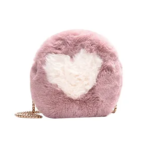 Round pink plush crossbody bag with white heart motif and gold chain strap for women