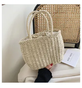 Detail of the woven straw tote with a fabric drawstring liner on a rustic background