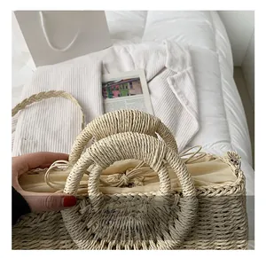 Dettaglio della borsa da spiaggia in paglia con fodera a coulisse beige e manici tondi