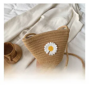 Détail du tissage en paille et de la broderie de marguerite sur le sac bandoulière seau