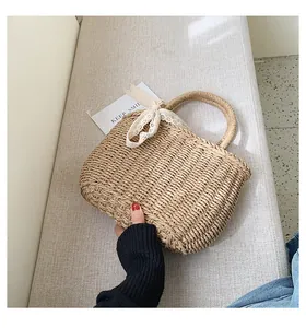 Detailed texture of straw handbag with lace ribbon bow on soft textile background