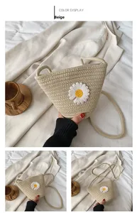 Détail du sac seau en paille beige avec broderie de marguerites et bandoulière