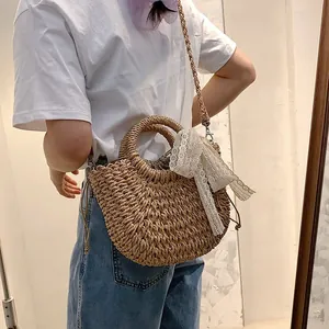 Handmade straw woven bag with lace bow and drawstring liner for beach holidays