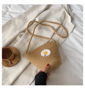 Détails de la texture d'un sac seau en paille avec un motif de marguerite blanche