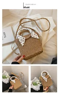 Detail of khaki straw woven handbag with decorative silk scarf and drawstring closure