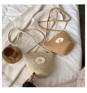 Détail de mini sacs seaux en paille avec marguerites 3D et fines bandoulières