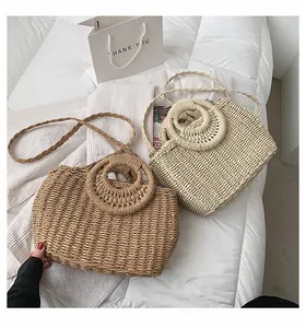 Dettaglio di borse in paglia intrecciata con trama fitta e manici rotondi in beige e marrone