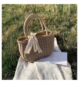 Macro shot of natural straw woven texture and white lace bow detail on the summer handbag