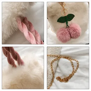 Detailansicht der flauschigen weißen Kirschtasche mit Samtgriff und Goldkettenriemen