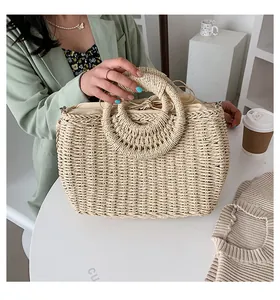 Dettaglio del grande manico circolare intrecciato e della texture in paglia della borsa