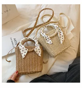 Detailed view of woven straw handbags with decorative silk handles and drawstring closure