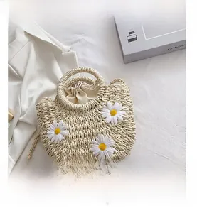 Straw basket bag featuring 3D daisy flowers and a cream drawstring lining detail