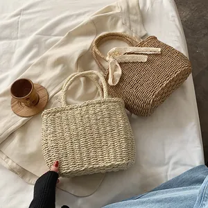 Handwoven straw beach bags in beige and khaki with decorative lace bow for summer travel