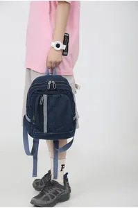 Detail van denim mini rugzak met blauwe stoffen banden en handige ritsvakken voor opslag
