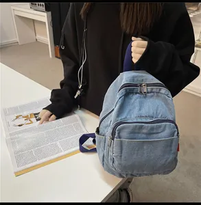 Λεπτομερής προβολή μίνι μπλε τζιν σακιδίου πλάτης με σχέδιο πολλών τσεπών και υφασμάτινες λαβές