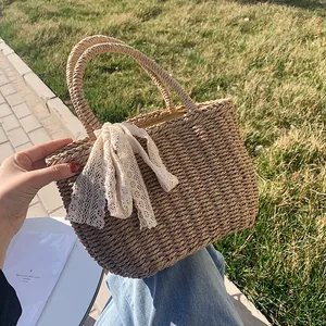 Handmade woven straw tote bag with lace bow decoration for summer beach vacations