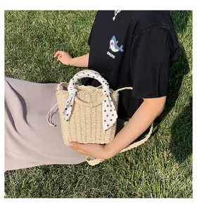 Detail of beige straw bucket bag with red diamond silk scarf and drawstring closure