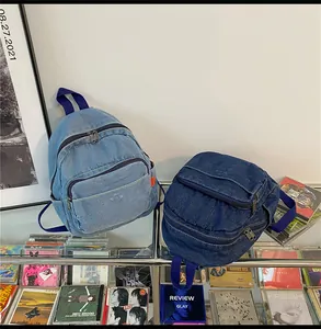 Λεπτομερής προβολή μίνι τζιν σακιδίων σε ανοιχτό και σκούρο μπλε μπροστά από ρετρό δίσκους CD