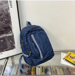 Gedetailleerd zijaanzicht van donkerblauwe denim minirugzak met ritssluitingen