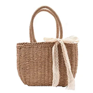 Large straw beach tote bag with woven handles and a cream lace bow decoration