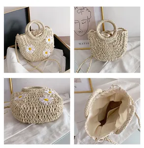 Detail view of woven straw tote with daisy flowers, ring handles and drawstring lining