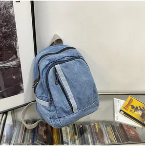 Detail van een mini denim rugzak met verstelbare bandjes op een vintage displayplank