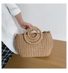 Dettaglio borsa in paglia intrecciata con manici rotondi e fodera interna in tessuto