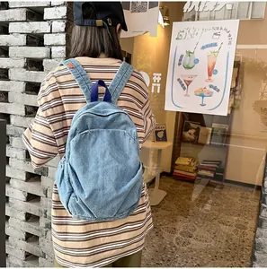 Vista trasera exterior de una mochila de mezclilla azul claro con gran capacidad de carga