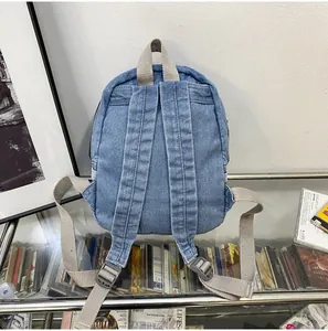 Detailopname van denim rugzakbanden met verstelbare gespen en lichtgrijze banden